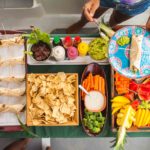 full meal for guests with a main course, fresh fruit, chips dips and drinks