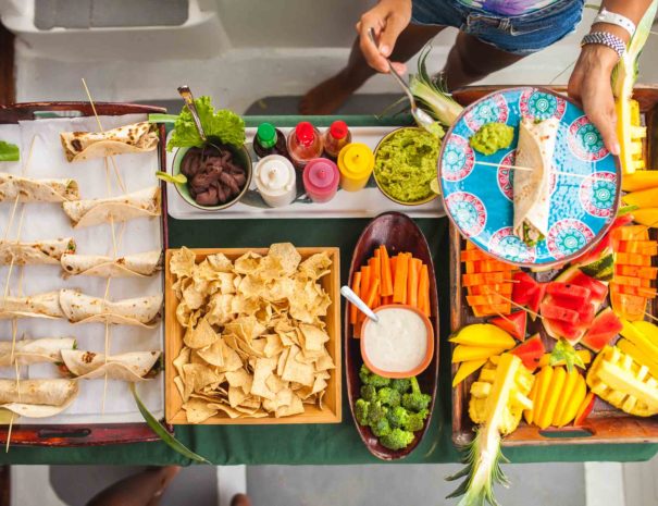 full meal for guests with a main course, fresh fruit, chips dips and drinks